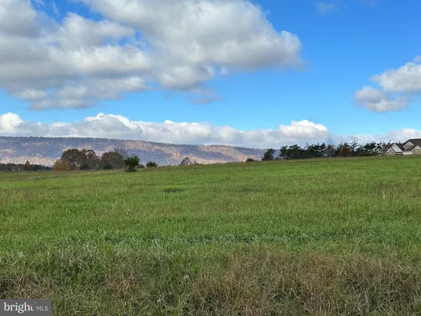 a view of an houses with yard and mountain view in back