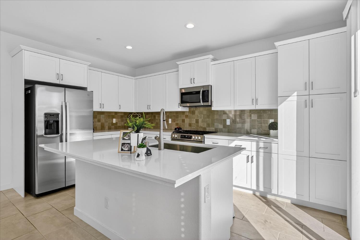 824 Katelyn Avenue Madera, CA 93636 - Photo 11 of 31 a kitchen with stainless steel appliances a refrigerator stove microwave and sink