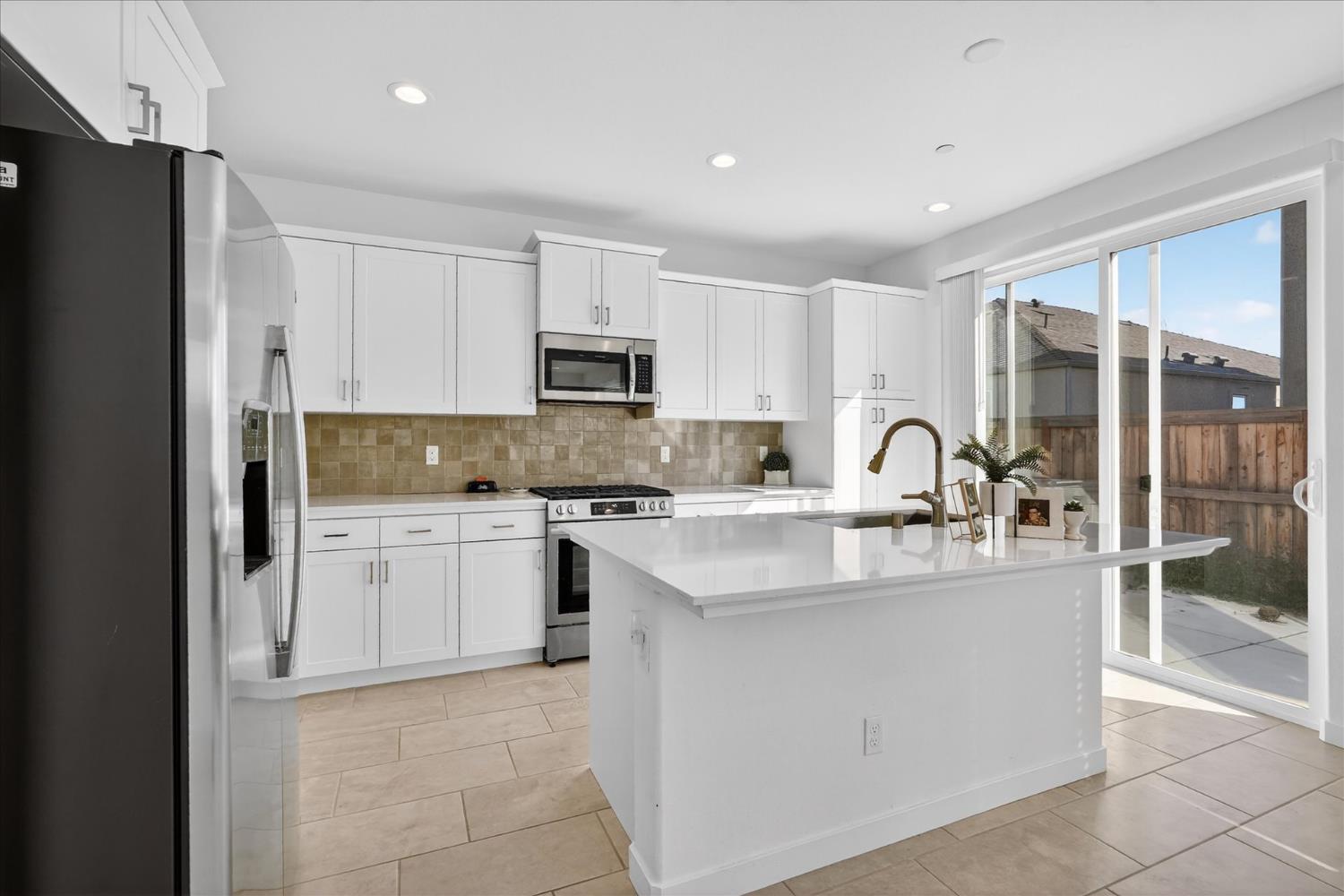 824 Katelyn Avenue Madera, CA 93636 - Photo 12 of 31 a kitchen with kitchen island a sink stainless steel appliances and cabinets