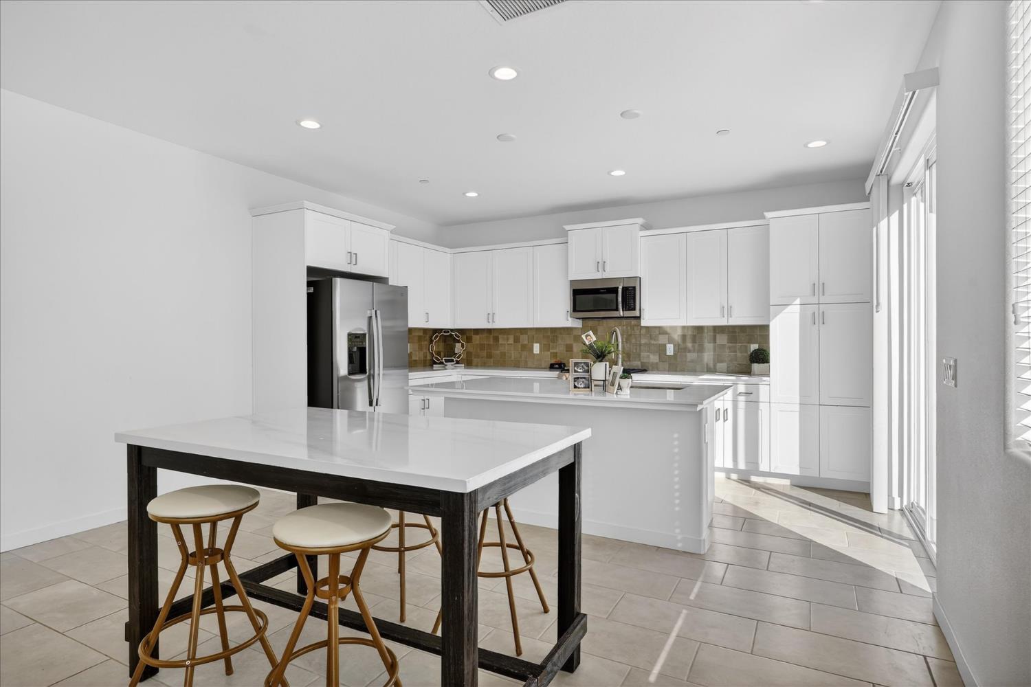 824 Katelyn Avenue Madera, CA 93636 - Photo 10 of 31 a kitchen with stainless steel appliances a table and chairs in it