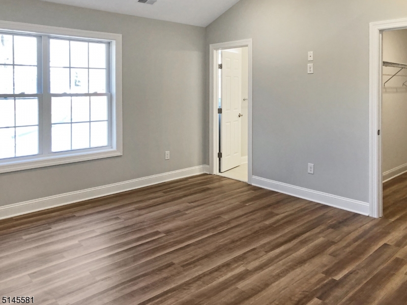 38 Old Shunpike Road, Unit A Randolph, NJ 07869 - Photo 3 of 8 an empty room with wooden floor and windows