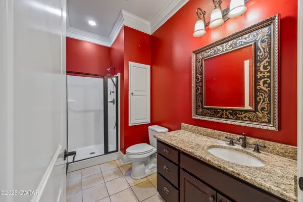 a bathroom with a granite countertop toilet sink and mirror