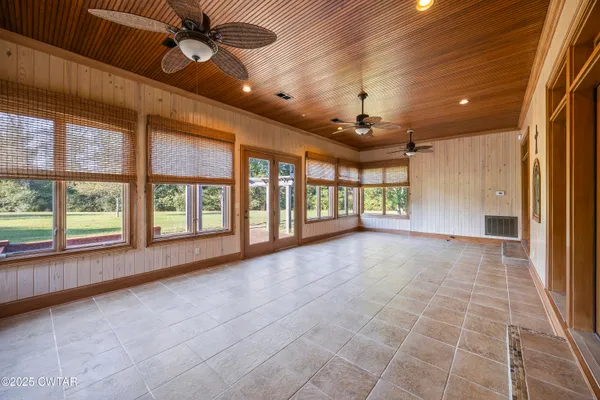 a spacious bathroom with a granite countertop double vanity sink a mirror and a bathtub