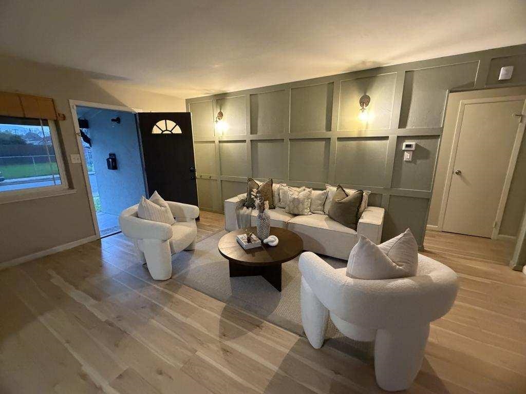 Living area featuring a decorative wall and light wood-style flooring