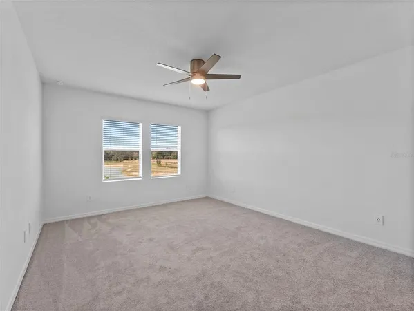an empty room with a window and a ceiling fan