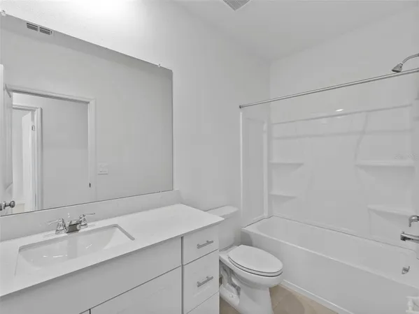 a bathroom with a granite countertop sink a toilet and a bathtub