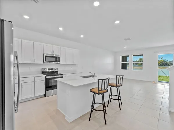 a kitchen with stainless steel appliances kitchen island granite countertop a sink and cabinets