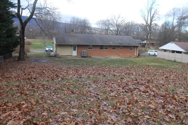 a view of a house with a yard and wooden fence