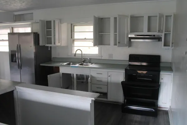 a kitchen with stainless steel appliances kitchen island granite countertop a stove and a refrigerator