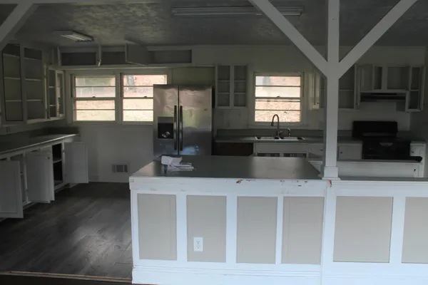 a kitchen with stainless steel appliances granite countertop a microwave a stove and white cabinets