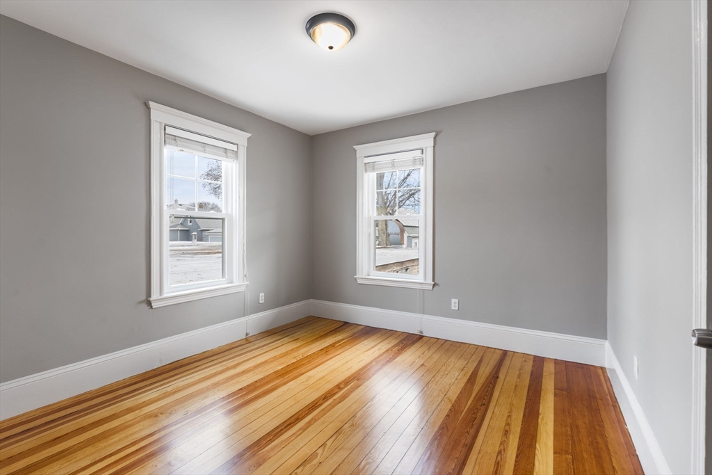 22 Clarendon Avenue, Unit 2 Somerville, MA 02144 - Photo 11 of 17 a view of an empty room with wooden floor and a window