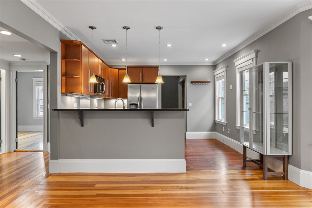 22 Clarendon Avenue, Unit 2 Somerville, MA 02144 - Photo 2 of 17 a view of a kitchen with a refrigerator and wooden floor