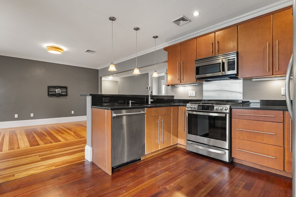 22 Clarendon Avenue, Unit 2 Somerville, MA 02144 - Photo 3 of 17 a kitchen with stainless steel appliances granite countertop a stove a sink and a microwave