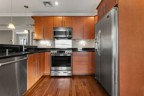 a kitchen with stainless steel appliances granite countertop a refrigerator and a stove