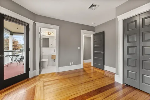a bedroom with a bed and wooden floor