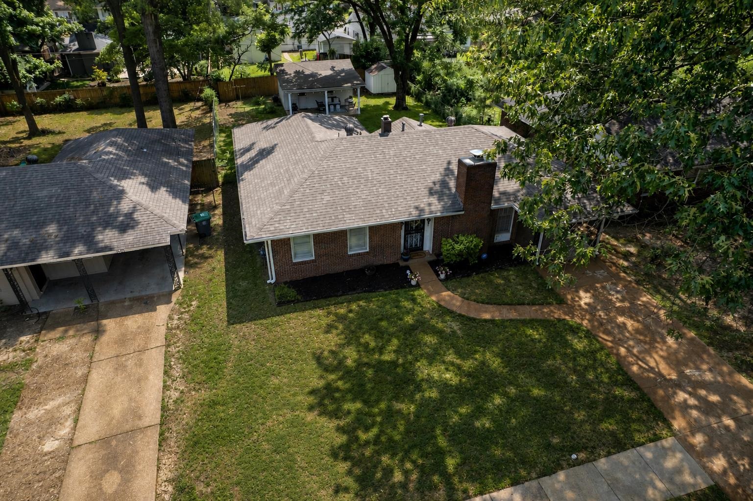 4491 Garnett Road Memphis, TN 38117 - Photo 29 of 32 Brick exterior residence with a shingled roof, featuring a curved concrete walkway to the front entrance