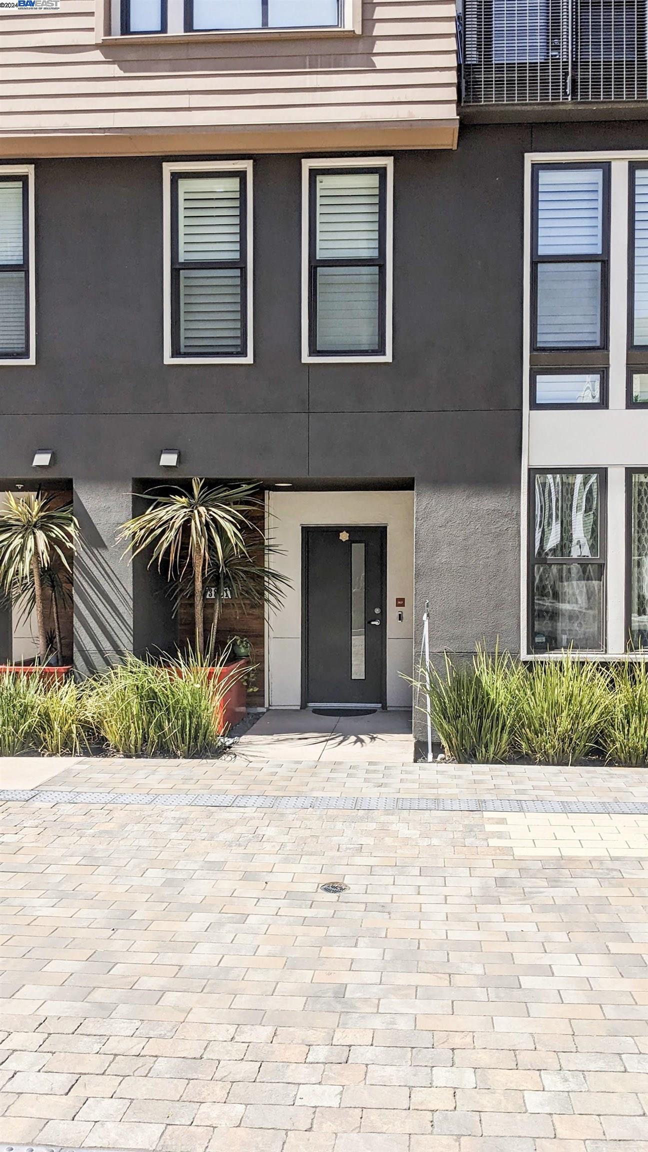 a front view of a house with a yard and potted plants