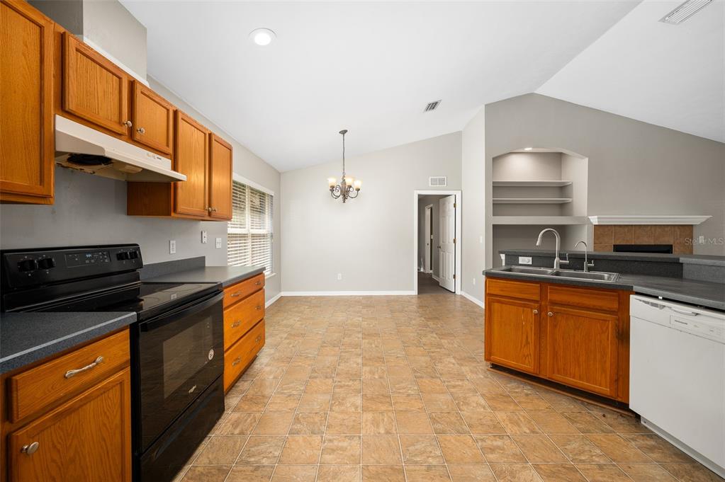 7462 Southwest 84th Drive Gainesville, FL 32608 - Photo 12 of 42 a kitchen with stainless steel appliances granite countertop a stove a sink and a refrigerator
