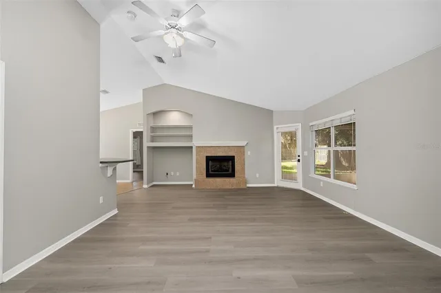 a view of an empty room with a fireplace and a window