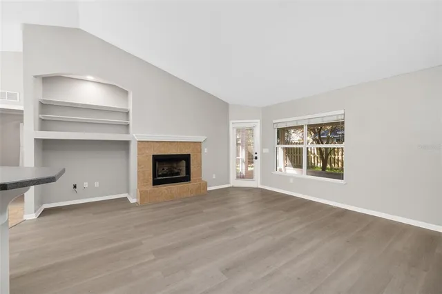 a view of an empty room with a fireplace and a window