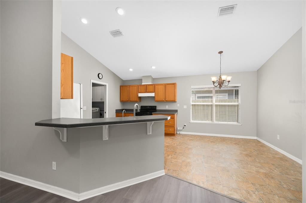 7462 Southwest 84th Drive Gainesville, FL 32608 - Photo 8 of 42 a large kitchen with stainless steel appliances a large counter top a stove a chimney a sink and a large window