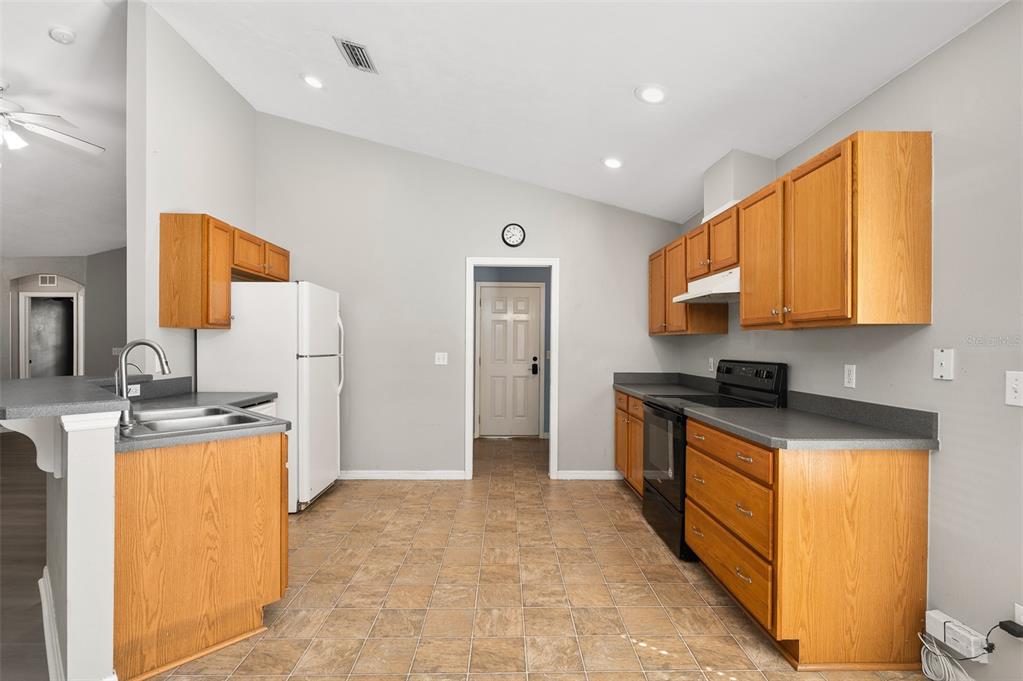 7462 Southwest 84th Drive Gainesville, FL 32608 - Photo 10 of 42 a kitchen with stainless steel appliances granite countertop a stove a sink and a refrigerator
