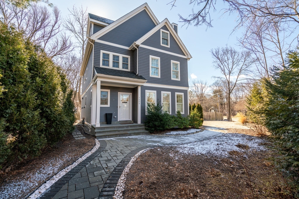 a front view of a house with garden and trees