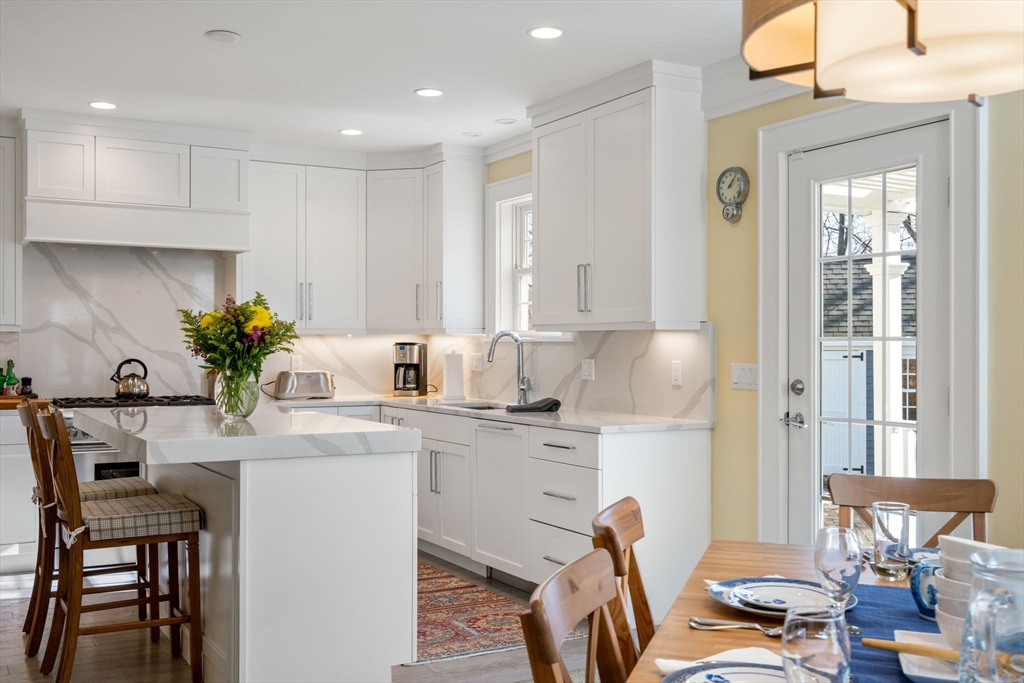 1404 Centre Street Newton, MA 02459 - Photo 6 of 42 a kitchen with stainless steel appliances granite countertop a table chairs in it and wooden floors