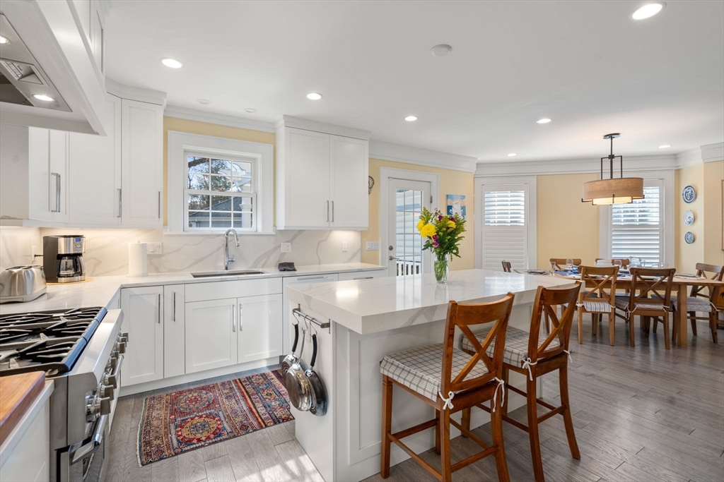 1404 Centre Street Newton, MA 02459 - Photo 8 of 42 a kitchen with stainless steel appliances granite countertop dining table chairs and white cabinets