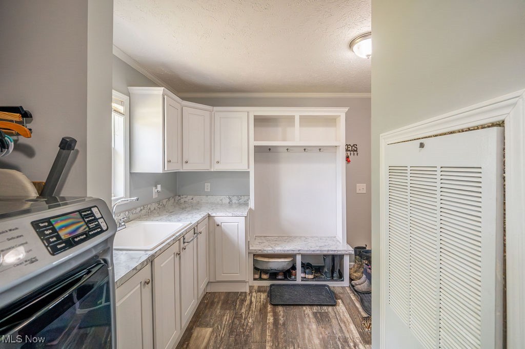 560 Wine Road Elizabeth, WV 26143 - Photo 6 of 50 Mudroom featuring washer / dryer, a heating unit, a textured ceiling, dark wood finished floors, and ornamental molding