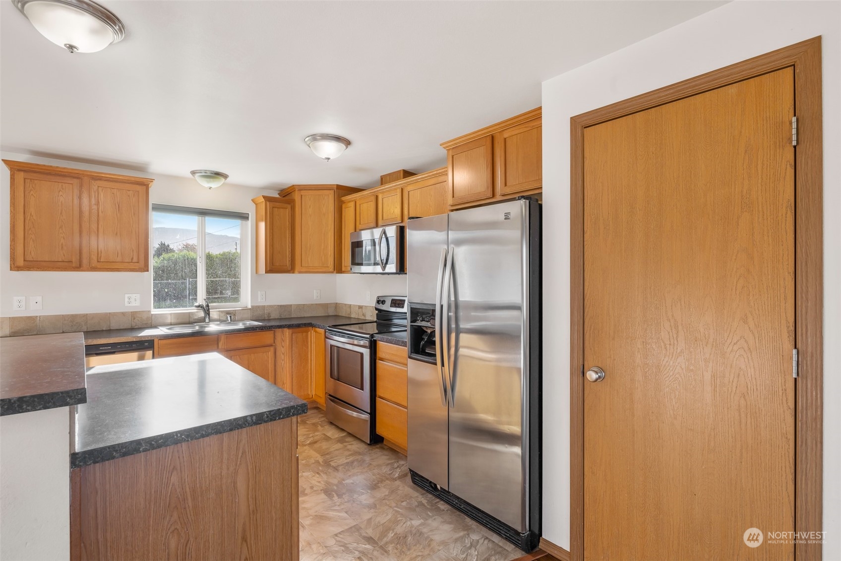 709 East Fir Street Sequim, WA 98382 - Photo 11 of 29 a kitchen with stainless steel appliances granite countertop a refrigerator and a sink