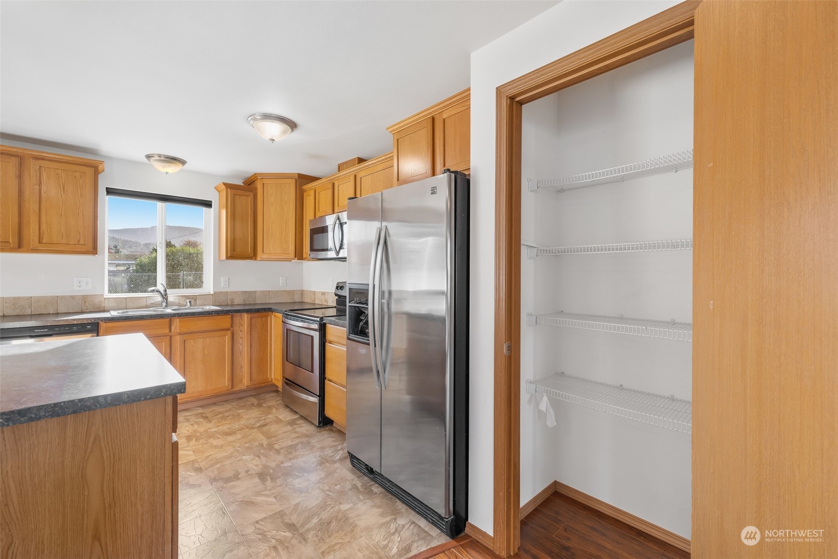 709 East Fir Street Sequim, WA 98382 - Photo 12 of 29 a kitchen with stainless steel appliances granite countertop a refrigerator and a sink