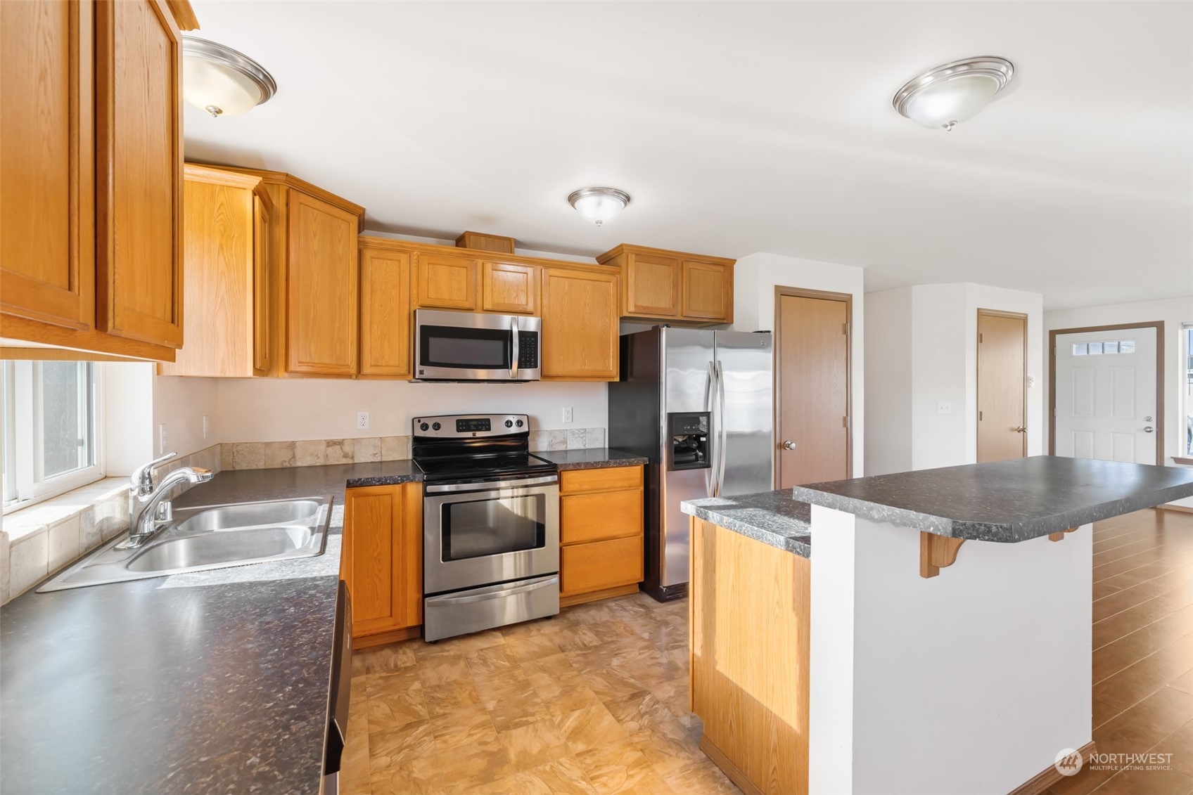 709 East Fir Street Sequim, WA 98382 - Photo 13 of 29 a kitchen with granite countertop a sink stove and refrigerator