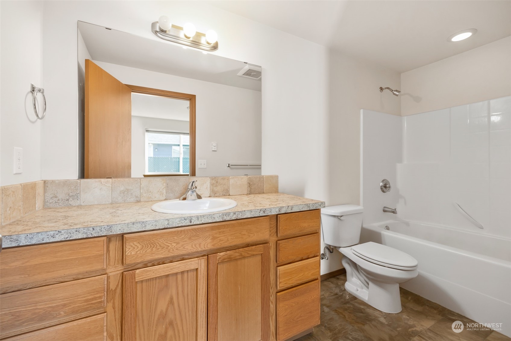 709 East Fir Street Sequim, WA 98382 - Photo 18 of 29 a bathroom with a granite countertop toilet a sink and a bathtub