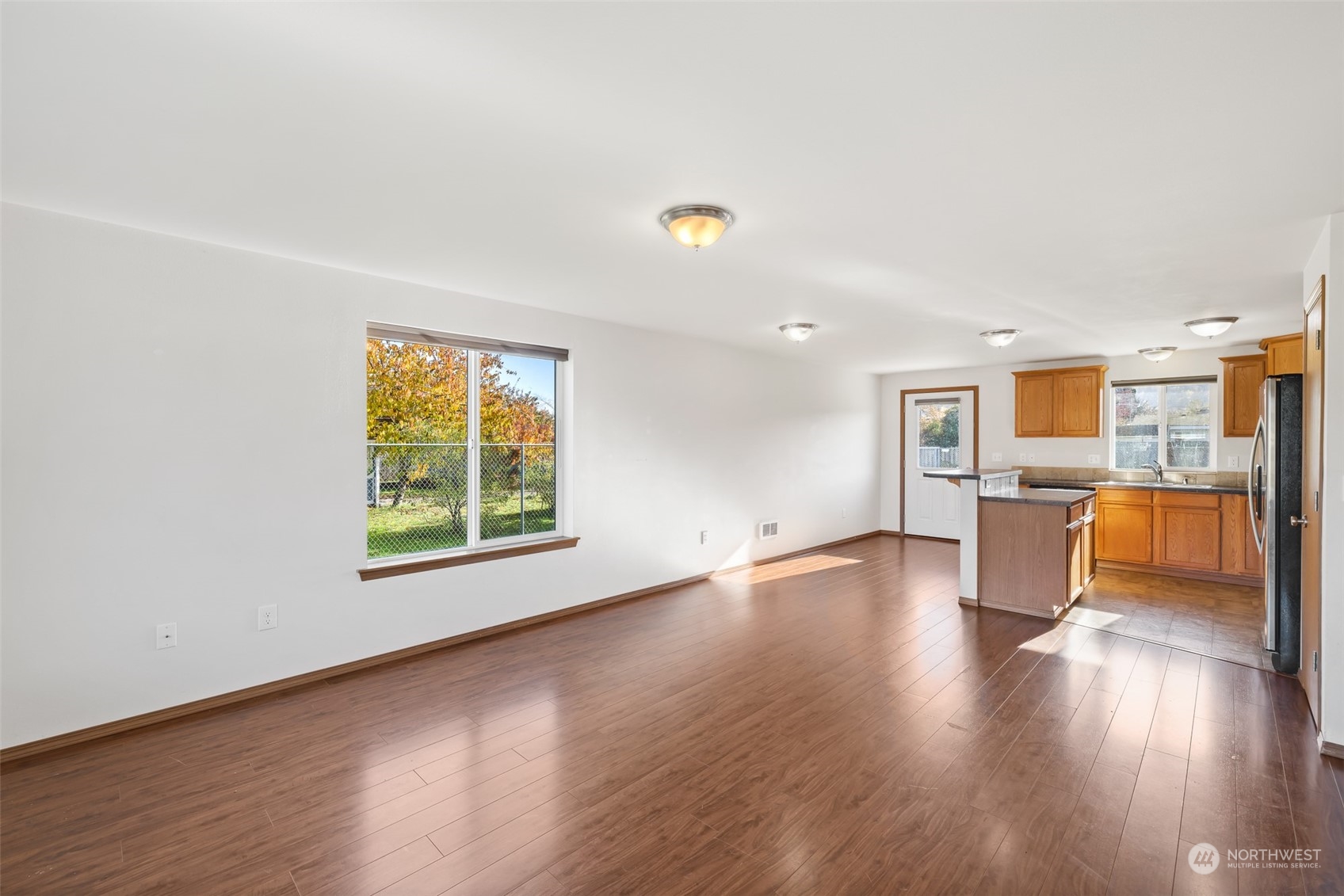 709 East Fir Street Sequim, WA 98382 - Photo 6 of 29 a view of a living room a kitchen with wooden floor and a window