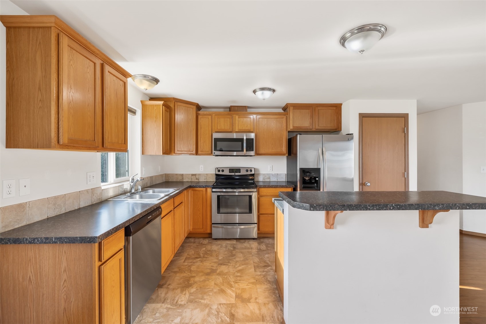 709 East Fir Street Sequim, WA 98382 - Photo 9 of 29 a kitchen with stainless steel appliances granite countertop a sink stove and refrigerator
