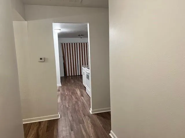 a view of a hallway with wooden floor