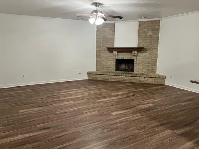 a view of empty room with wooden floor and fireplace