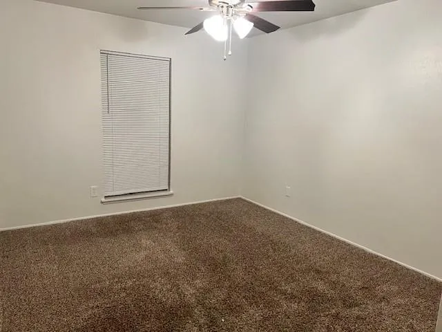an empty room with a chandelier fan