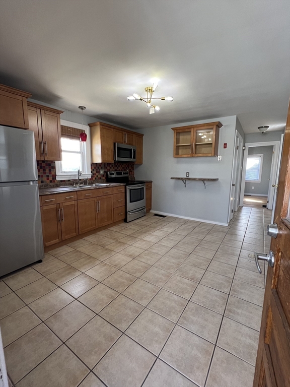 39 Phebe Avenue Lowell, MA 01854 - Photo 3 of 13 a kitchen with stainless steel appliances granite countertop a refrigerator and a stove top oven