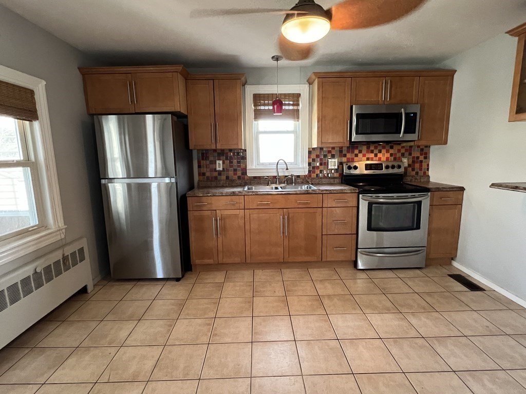 39 Phebe Avenue Lowell, MA 01854 - Photo 5 of 13 a kitchen with stainless steel appliances a refrigerator sink and microwave