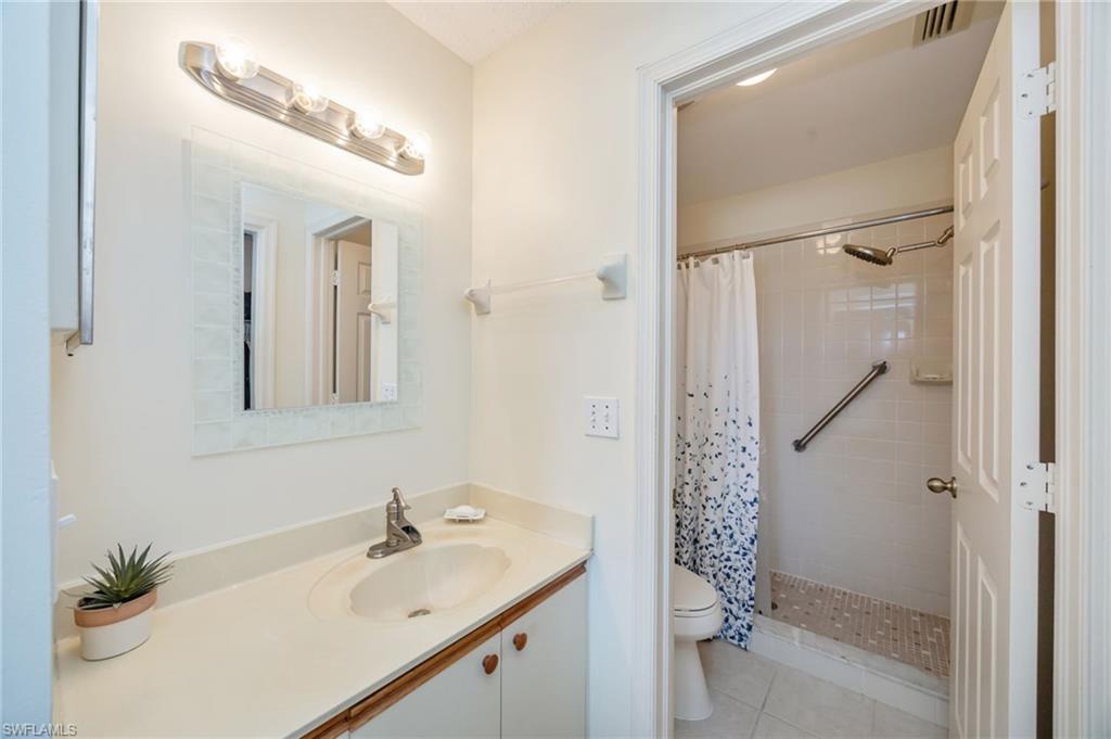 5940 Cranbrook Way, Unit A206 Naples, FL 34112 - Photo 14 of 50 a bathroom with a shower sink and mirror