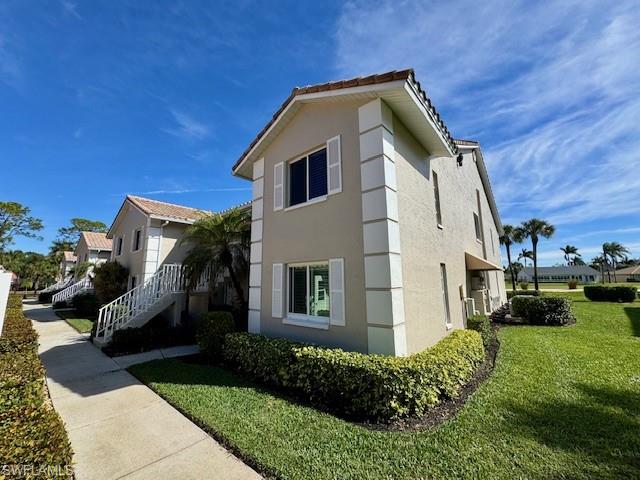 5940 Cranbrook Way, Unit A206 Naples, FL 34112 - Photo 2 of 50 a front view of a house with a yard