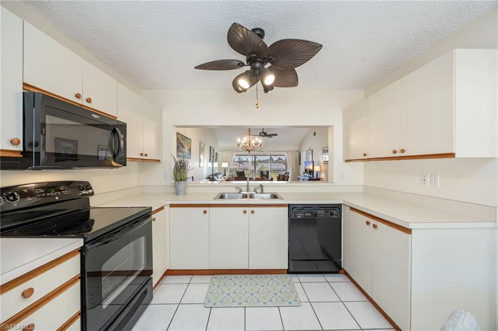 5940 Cranbrook Way, Unit A206 Naples, FL 34112 - Photo 7 of 50 a kitchen with a sink stainless steel appliances and cabinets
