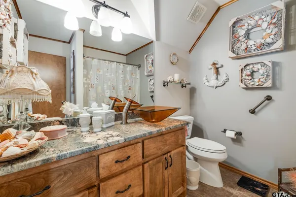 a bathroom with a granite countertop toilet sink and mirror