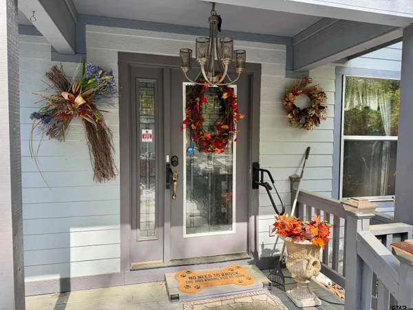a vase of flowers sitting on a table in front of a door