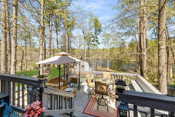 a view of a patio with couches table and chairs under an umbrella
