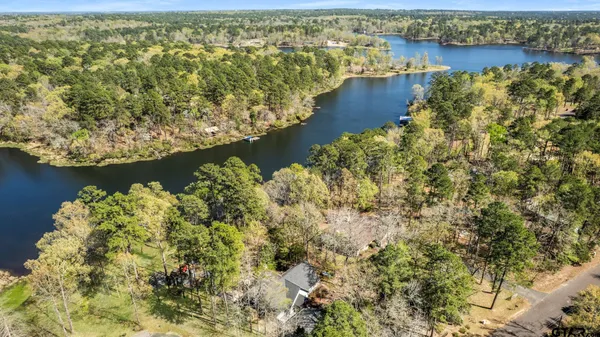 an aerial view of residential houses with outdoor space and lake view