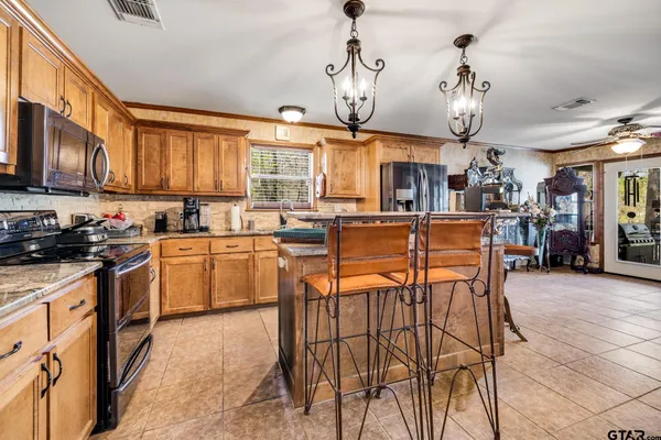 a kitchen with stainless steel appliances kitchen island granite countertop a sink and cabinets