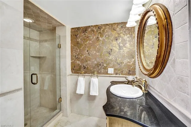 a bathroom with a sink a mirror a toilet and a shower